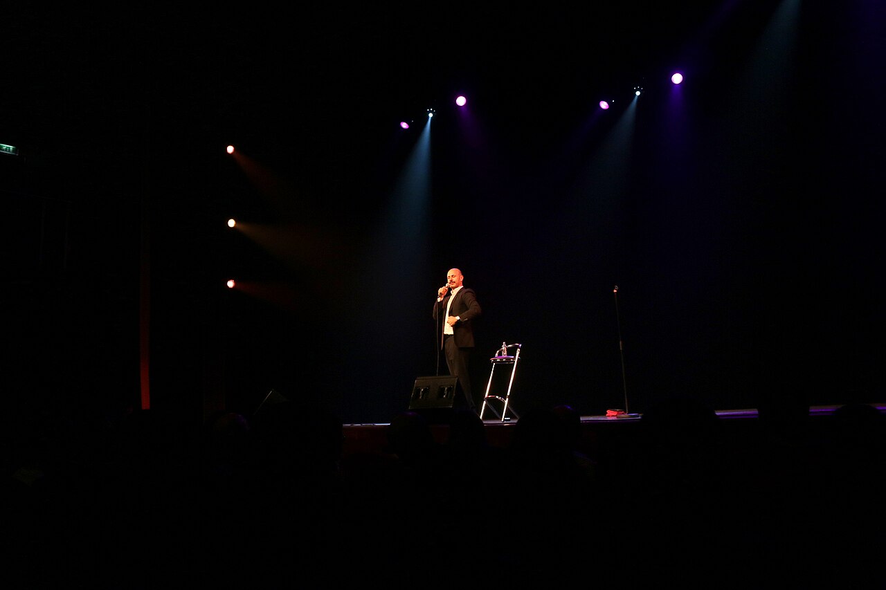 Maz Jobrani, Iranian-American comedian, performing stand-up at Meervaart Theater Amsterdam in 2014 — the bilingual diaspora stage Ghazaleh Ghasemi was built to host.