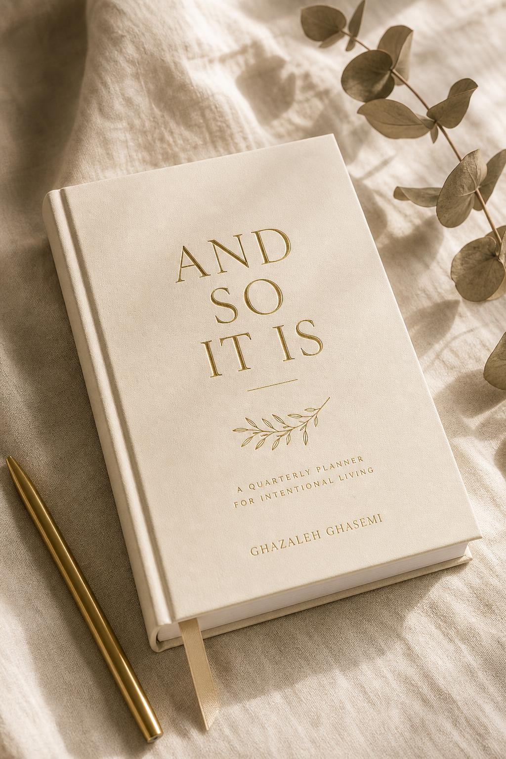 Neutral Edition of And So It Is quarterly goal planner for neurodivergent minds by Ghazaleh Ghasemi — bone, ink and gold-leaf cover styled with dried botanicals on a dark walnut table.